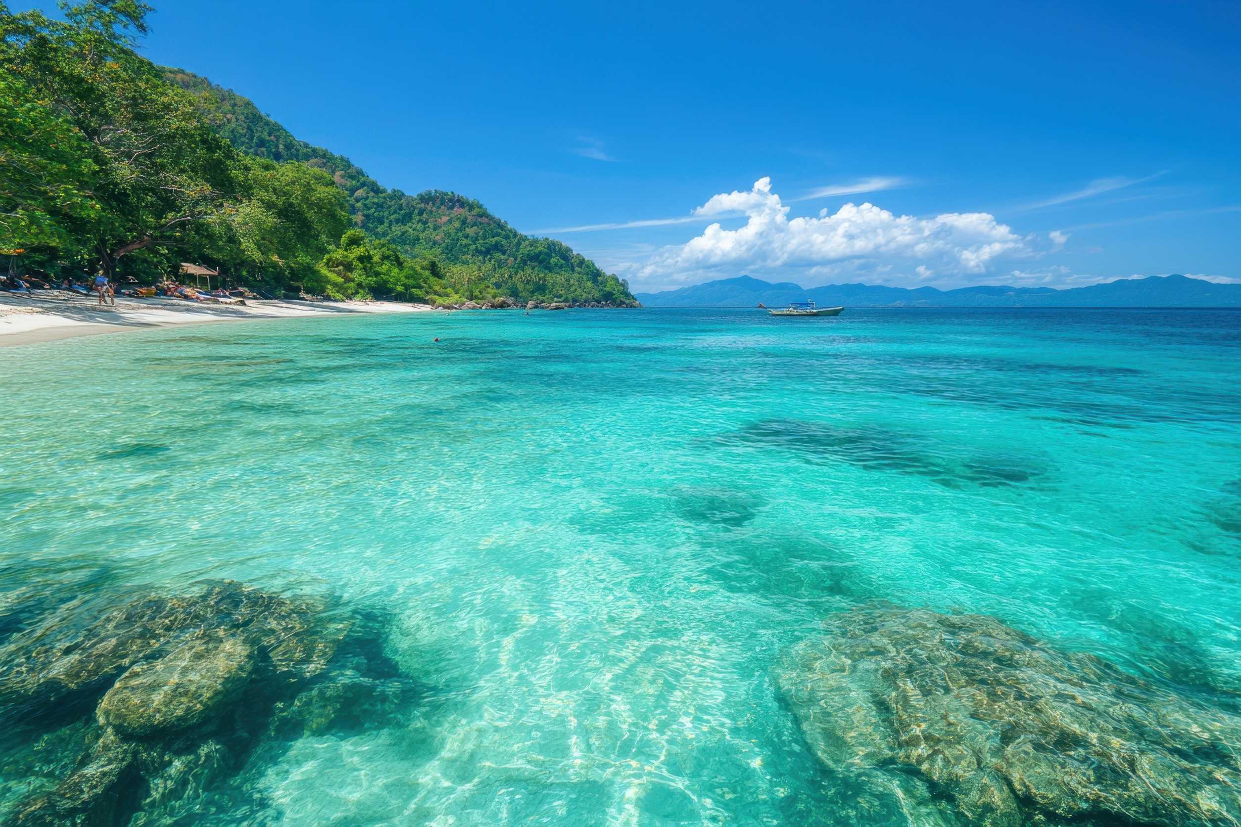 Crystal Clear Water Reflects The Sun As It Meets The Sandy Beach